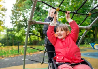 a girl playing on a inclusive accesible playground