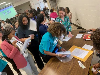 people gathered at a table filing out forms at the workshop