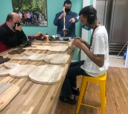 a group of men working with wood on a table