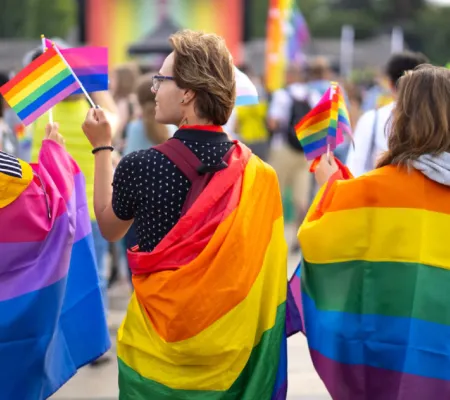 Group of people in a celebration of PRIDE month; rainbow flags