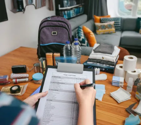 A person checking a list of necessities for a hurricane kit