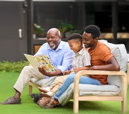 Grandpa, son and grandson reading a book