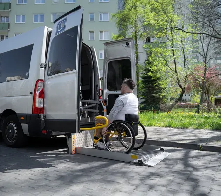 A man in a wheel chair getting a ride