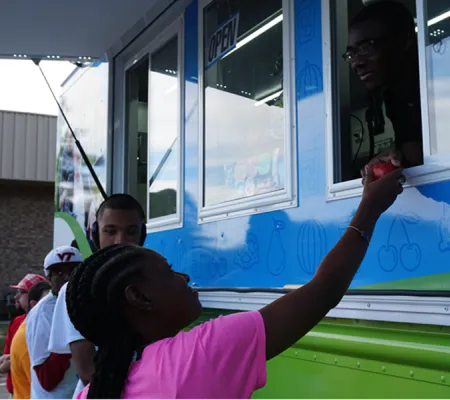 A young girl buying food in a food truck