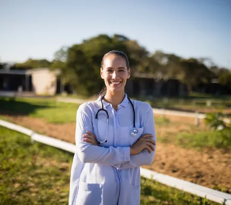 a female doctor standing infront of a rural landscape