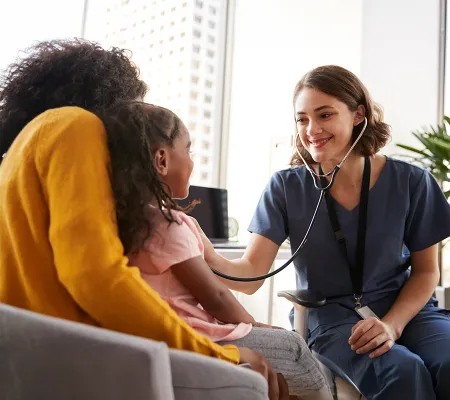 A doctor with a child and the mother putting the stethoscope to the child