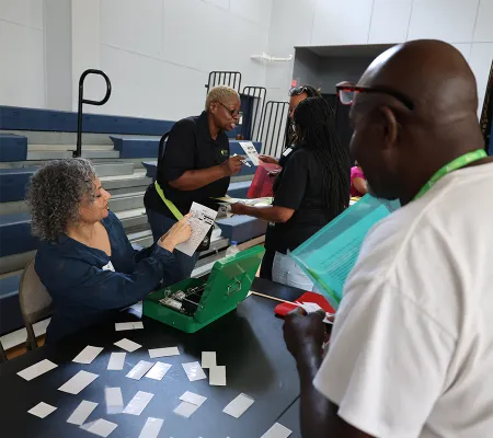 A woman showing a card to a participant on an event