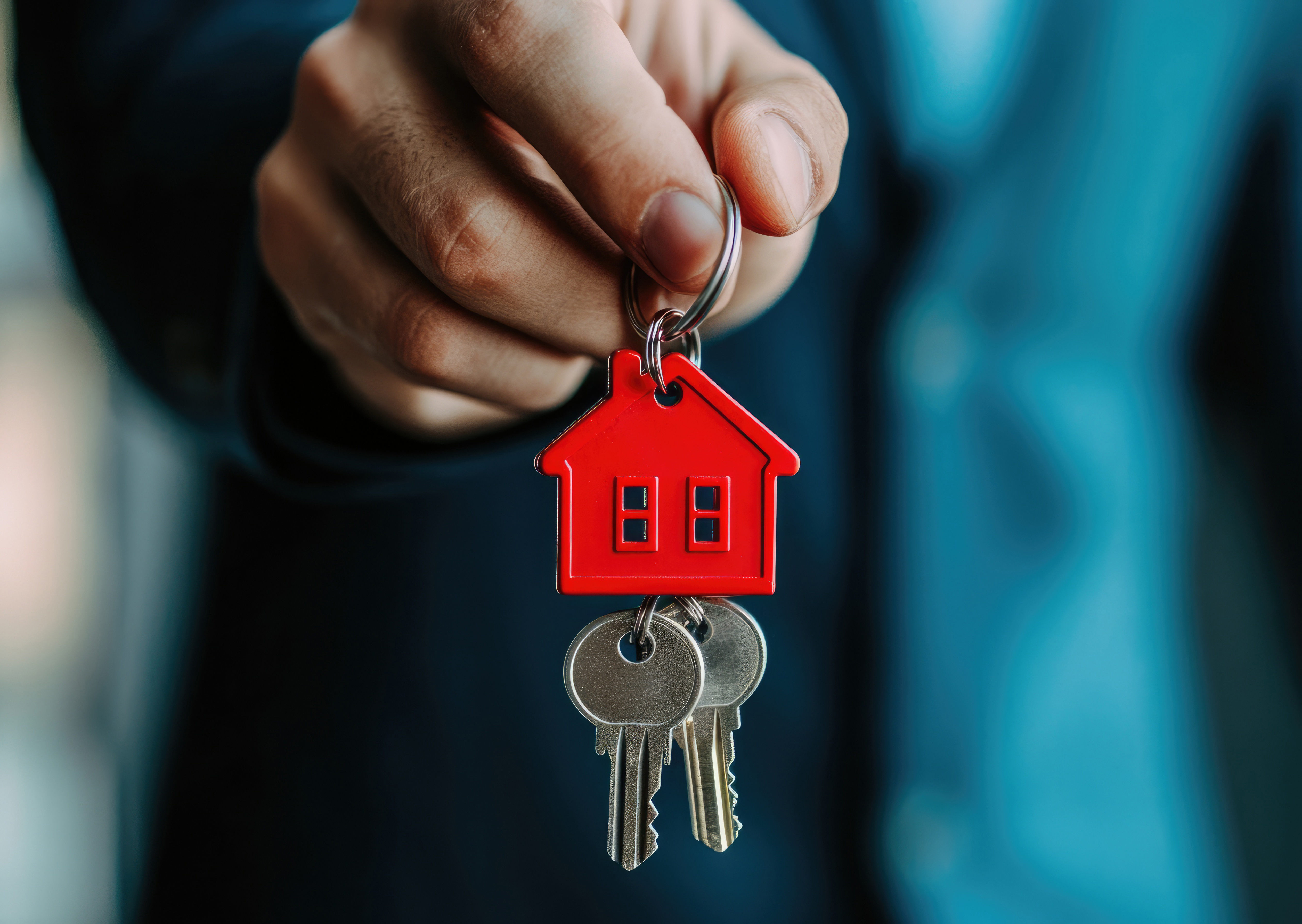 A hand with a key on a house key chain