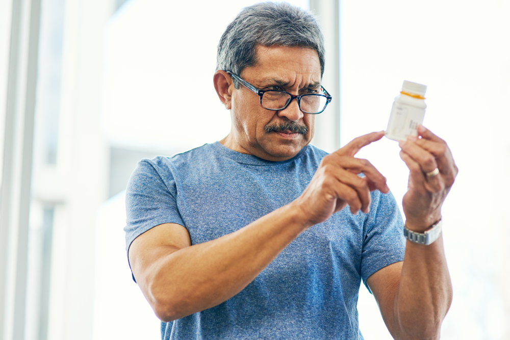 A man reading a bottle of pills