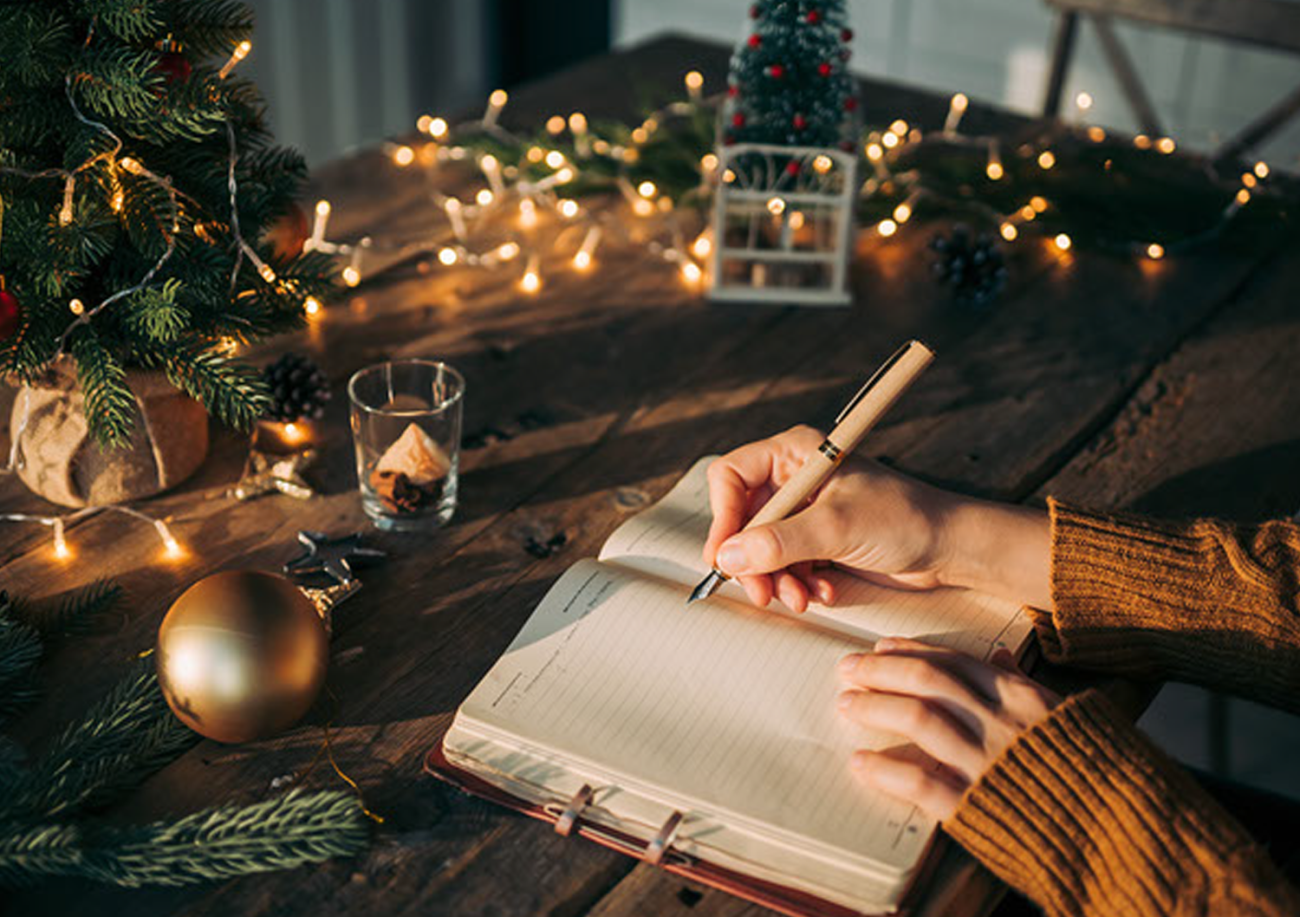 a photo of hands writing in a journal
