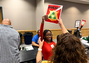 A young woman with a red blouse holding a sign with "police" word, on a training