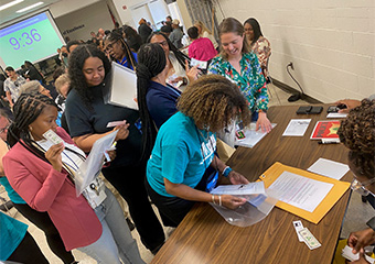 Attendees of the Re-Entry Simulation training in front of a table waiting for their turn