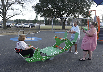 a girl playing on the Seesaw with her family