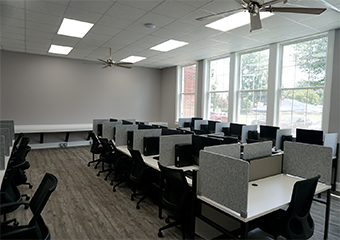 A room with cubicles and every cubibles a computer