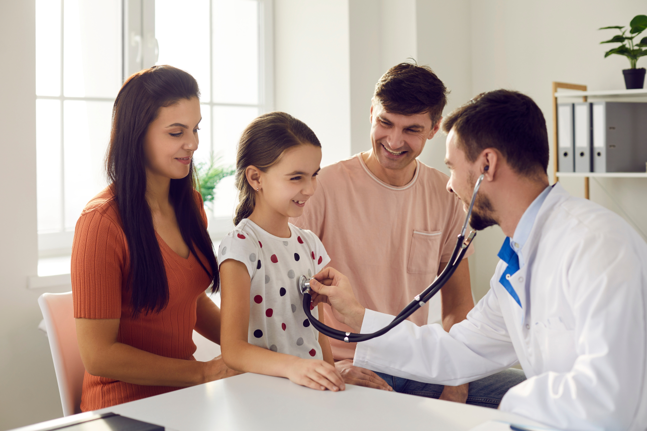Parents and doctor with a child hearing the heart